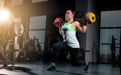 fit young woman lifting barbells looking focused working out gym