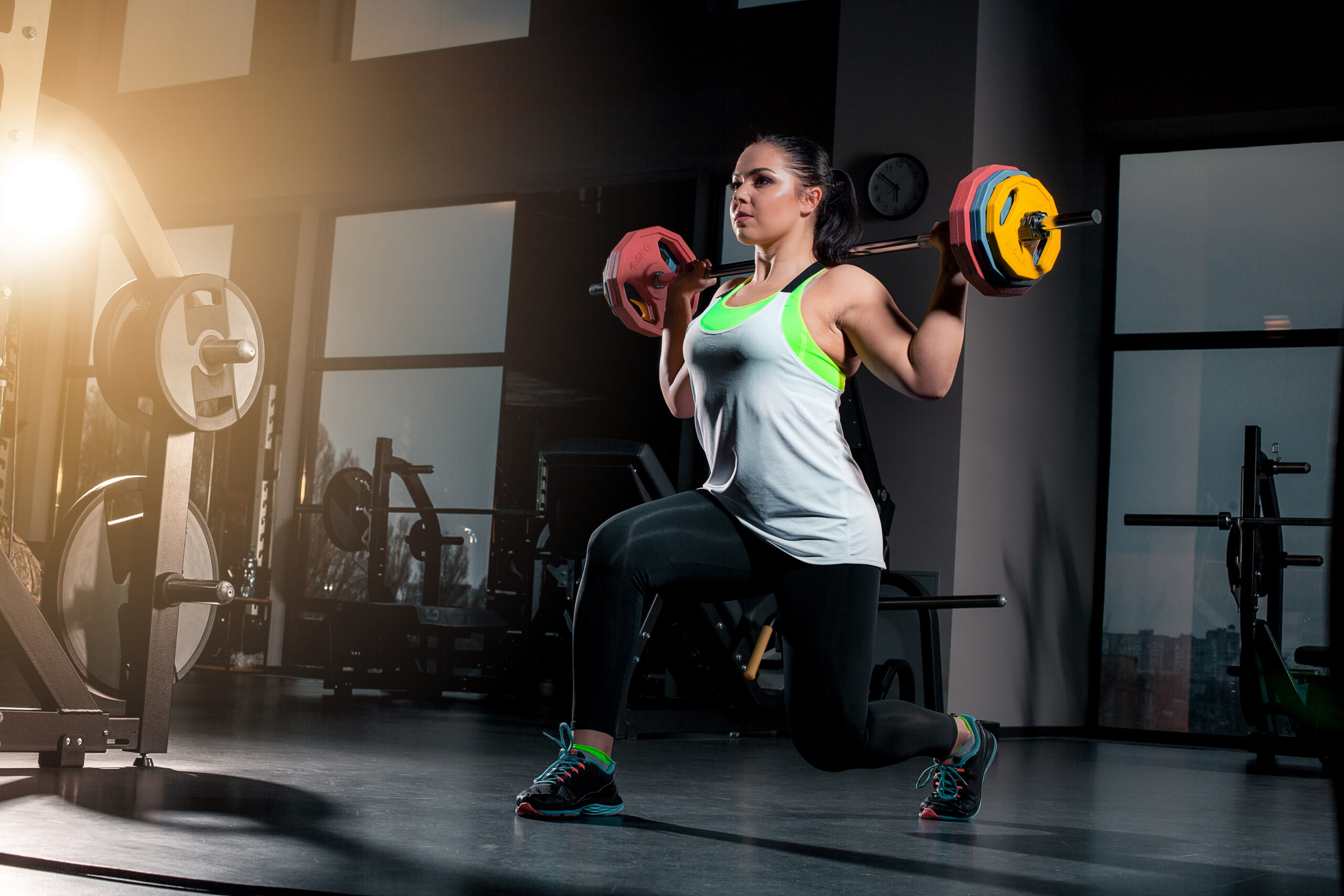fit young woman lifting barbells looking focused working out gym scaled