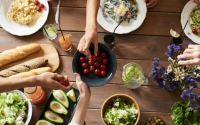 Meal Planning for Men Over 35 - group sharing a healthy meal with salads, avocados, and fresh vegetables.