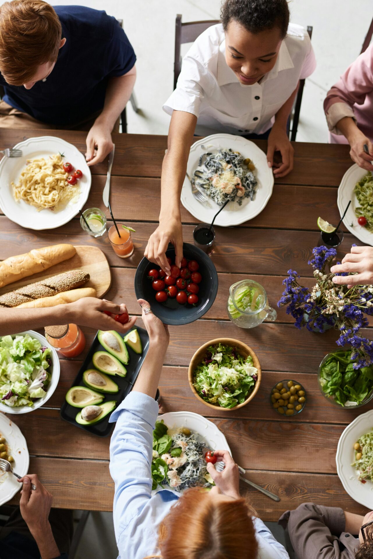 Meal Planning for Men Over 35 - group sharing a healthy meal with salads, avocados, and fresh vegetables.
