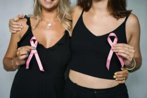 Women holding pink ribbons for breast cancer awareness.