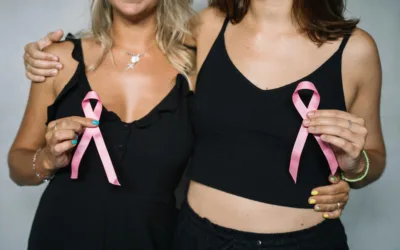 Women holding pink ribbons for breast cancer awareness.